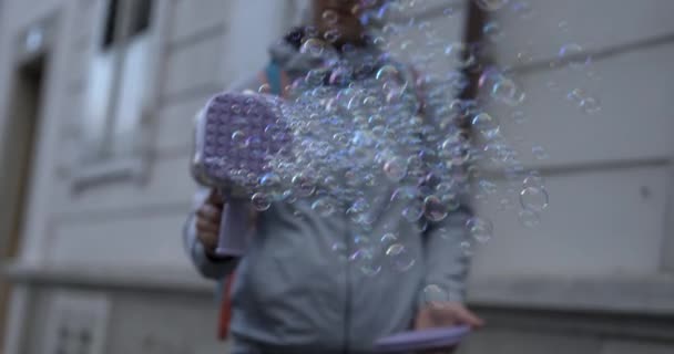 スーパースローモーションでおもちゃガンで空気中の無数の石鹸泡をランチする人 — ストック動画