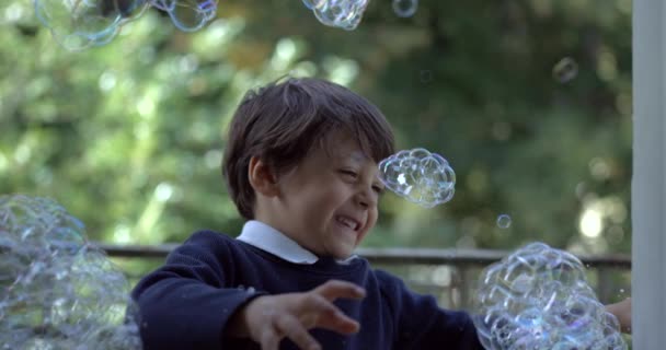 Радісна Дитина Вкрита Мильними Бульбашками Намагається Розірвати Руками Захопленими Супер — стокове відео