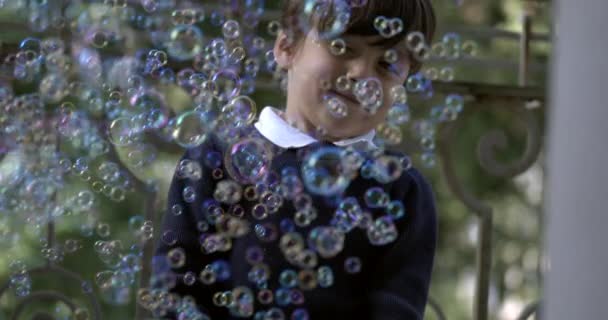 Ευτυχισμένο Παιδί Που Διασκεδάζει Χιλιάδες Σαπουνόφουσκες Απολαυστική Έκφραση Που Συλλαμβάνεται — Αρχείο Βίντεο