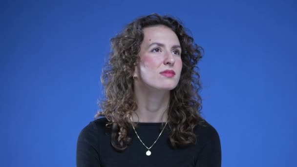 Derin Düşüncelere Dalmış Bir Kadının Düşünceli Bakışları Mavi Arka Planda — Stok video