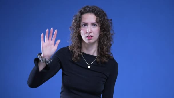 Kvinna Gestikulerar Till Kameran Med Händerna Signalerar Hej Med Nervöst — Stockvideo