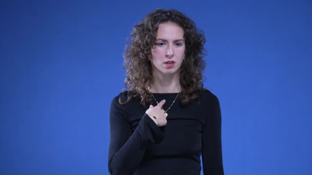 女人困惑地指着自己 手指充满怀疑和恐惧地站在蓝色的背景上 20个人对指控的反应 — 图库视频影像