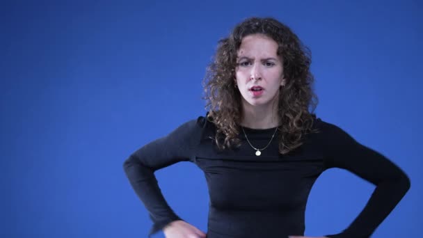 Mulher Chocada Reagindo Com Perplexidade Fundo Azul Com Mãos Quadril — Vídeo de Stock