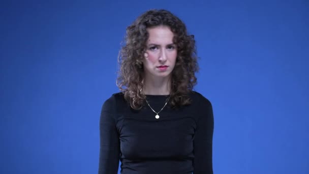 オファーを拒否する女性 20代 青い背景に立っている質問を否定する人 — ストック動画
