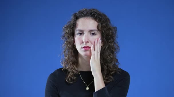 二十多岁的女人焦虑地感到紧张 满心焦虑地站在蓝色的背景上 沉思地沉思着 — 图库视频影像