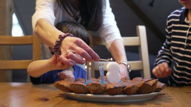 Doğum günü kutlaması, çocukların 8 yaşındaki çocuk kutlaması sırasında mum yakması. Pastanın önünde iki kardeş.