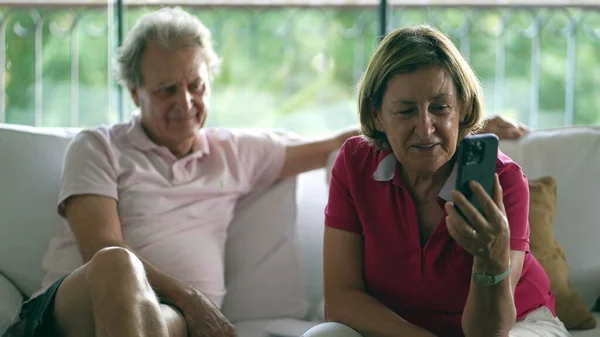 Joyful grandparents in Video Chat - Sharing Moments with Distant Family, Delighted Senior Lady on Couch Engaging in Heartfelt Long-Distance Talk with relatives