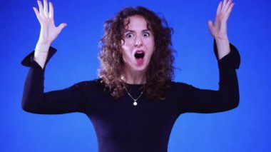 Mavi arka planda patlayıcı bir jestle Eureka Anı 'nı Yaşayan Şok Kadın