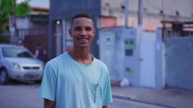 Caddede kameraya gülümseyen neşeli bir Brezilyalı genç adam. 20 'li yaşlarda Güney Amerikalı, gerçek hayattaki insanlar.