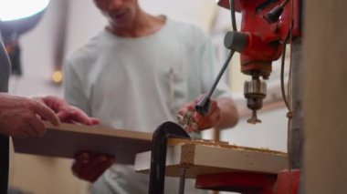 Sanayi makinesinin yanındaki marangozluk atölyesinde çalışan Brezilyalı genç bir marangoz.