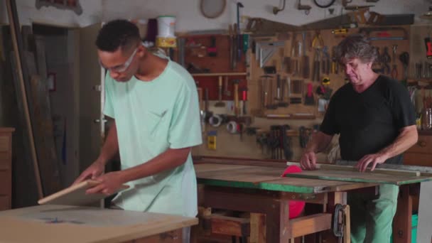 木工職人のワークショップで働く見習いと大工のカペントリーシーン 職業に従事する候補者 — ストック動画