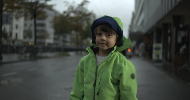 Glada Barn Står Regnet Bär Grön Regnrock Urban Gatumiljö Porträtt — Stockvideo