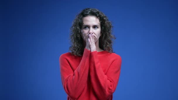赤いセーターで青い背景に立っているジレンマに苦労する高価な女性 厳しい意思決定の間に20代の思慮深い — ストック動画