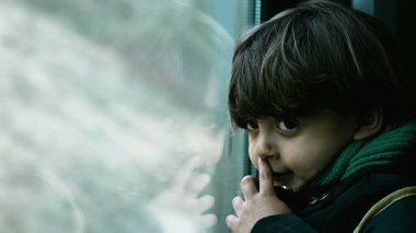 Trenden manzaraya bakan düşünceli bir çocuğun yakın plan portresi, yolculuk sırasında çocuk profili.