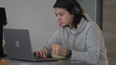 Sabahları mısır gevreği yerken internetten içeriğe bakan bir kadın. Bilgisayar tarama interneti önünde birden fazla görev