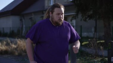 Dışarıda egzersiz yapan şişman bir genç adam. Tombul bir erkeğin koşarkenki görüntüsü. Fitness konseptine dönelim.