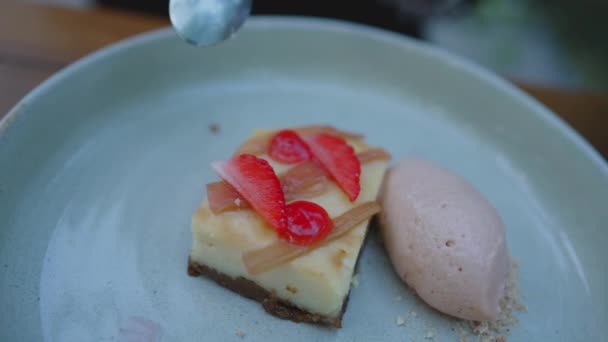 在高档餐厅里特写精美的甜食 在上面吃草莓片的芝士蛋糕甜食 在旁边吃一勺冰激凌 — 图库视频影像