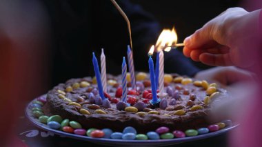 Yakın plan doğum günü mumları, çocuk kutlaması çikolatalı pasta.