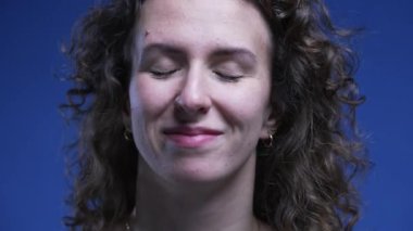 Kadının gözlerini kapattığı, görevi tamamladıktan sonra gülümseyen yüzü. 20 'li yaşlarda, mutlu ve rahat hisseden insanların stressiz duyguları.