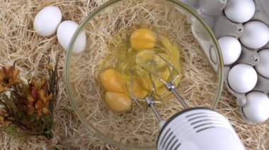 Elektrikli el bilgisayarı ile omlet hazırlama, otomatik yumurta çırpma perspektifi Wad Barley saman ve arka planda yumurta, ev yapımı tarım arazisi konsepti