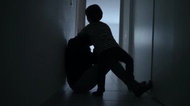 Depresyondaki annesini teselli eden çocuk apartman koridorunda anksiyete yüzünden acı çekiyor. Zor zamanlarda annesini kucaklayan küçük bir oğul.
