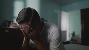 Çaresiz yaşlı adam umutsuzluk ve yalnızlıktan muzdarip yüzünü kapatıyor. Yaşlı, orta yaşlı, utançla kaplı, kaygı ve akıl hastalıklarıyla boğuşan biri.