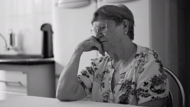 Przygnębiona Seniorka Wieku Lat Wyrażająca Samotność Samotność Siedząca Kuchni Monochromatycznej — Wideo stockowe