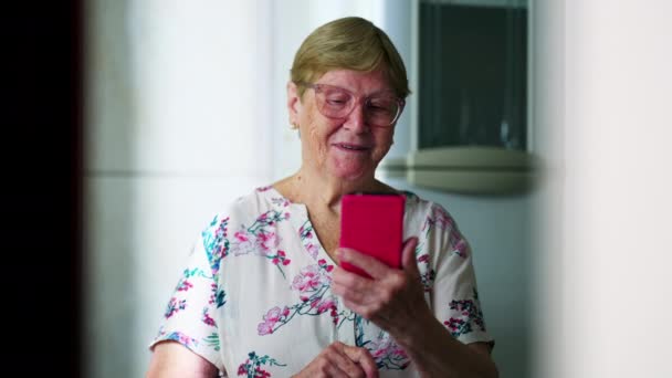 Старшая Женщина Просматривает Интернет Интернете Мобильного Телефона Отображая Счастье — стоковое видео