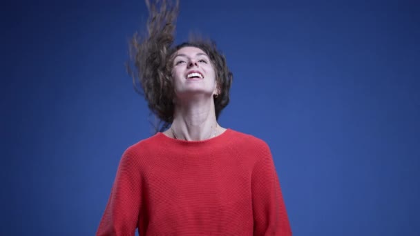 Молодая Женщина Поднимает Волосы Воздухе Регулируя Волосы Синем Фоне — стоковое видео
