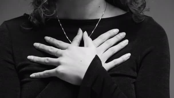 ウーマンによる心温まる感謝のジェスチャー 芸術的な黒と白のクローズアップで胸に手 — ストック動画