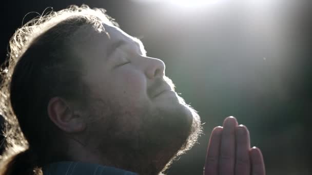 宗教的な若者は 神の恵みを感じる空に向かって目を開きます スピリチュアルな希望の太りすぎの男性 — ストック動画