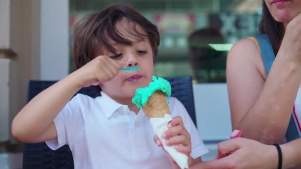 여름날에는 가게에서 아이스크림 즐기는 어머니는 염색하지 않도록 소년의 가까이 가져옵니다 — 비디오
