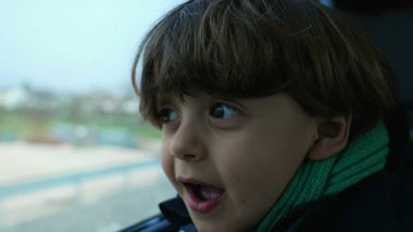 Hızlı trenden eşarp ve ceket giyerek gezen heyecanlı çocuk. yolcu küçük çocuk