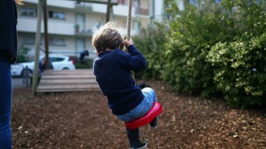 Ağaçlar Arasında Halattan Aşağı Kayan Neşeli Küçük Çocuk, Yakın plan. Nostaljik sahne betimlemesindeki çocuk parkı