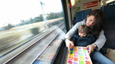 Proaktif bir anne, hızlı tren yolculuğu sırasında oğluna eğitim faaliyetlerini kolaylaştırıyor. Hareket hâlindeki çocukluk eğitimini örnek alıyor.