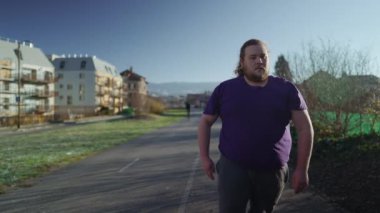 Koşmadan önce dışarıda duran kilolu bir genç adam. Zihinsel olarak egzersiz yapmaya hazırlanan kişi motivasyon kavramı