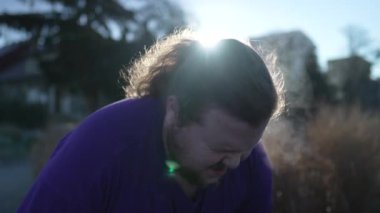 Yorgun, şişman bir genç adam koştuktan sonra derin bir nefes alıyor. Diz çökmüş kilolu beyaz bir erkek mola verir. Spor yaşam tarzı