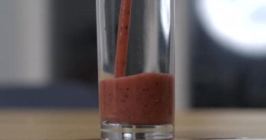 Smoothie 'yi ağır çekimde çekilen cama servis ediyorum. Kırmızı detoks sıvısı dökülüyor.