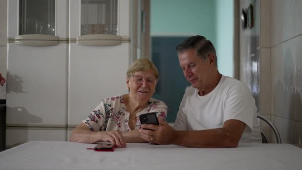 가정용 테이블에서 스마트폰 기기로 어머니를 나이를 어머니를 기술로 지원하는 — 비디오