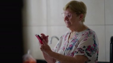 Cep telefonunda internet gezen yaşlı kadın, Teknoloji Tasarruf Yaşlısı Ev Teknolojisi ile Nişanlı