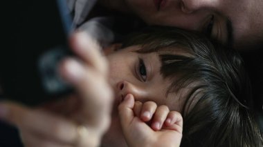 Anne ve Çocuğun Yakın Çekimi, Yatakta Yatarken Cep Telefonu İçeriğini İzlerken Özümsenmiş
