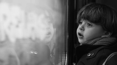 Yüksek hızlı tren ulaşımından manzaraya bakan tek renkli düşünceli bir çocuk. Düşünceli bir çocuk yolcunun siyah beyaz klipsi.