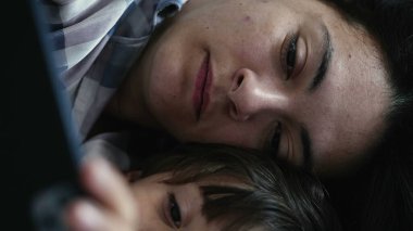 Anne ve Çocuğun Yakın Çekimi, Yatakta Yatarken Cep Telefonu İçeriğini İzlerken Özümsenmiş