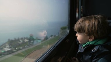 Trenin penceresinden dışarı bakan küçük çocuk, Yüksek Hızlı Ulaşım Çocuk Yolcusunun Yüksek Görüş Alanı