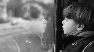 Yüksek hızlı tren ulaşımından manzaraya bakan tek renkli düşünceli bir çocuk. Düşünceli bir çocuk yolcunun siyah beyaz klipsi.