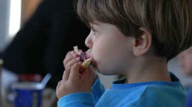 Küçük Kafkas Çocuk Kahvaltıda Jöleli Brioche 'nin tadını çıkarıyor, Çocuk Kutlama Sabah Karbonhidratı
