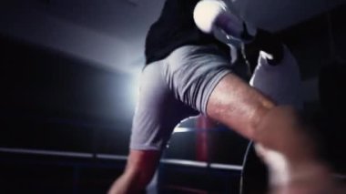 Dövüşçülerle antrenman maçı boks ringinde yumruk atma, rakipler arasında çarpıcı ışıklandırma.