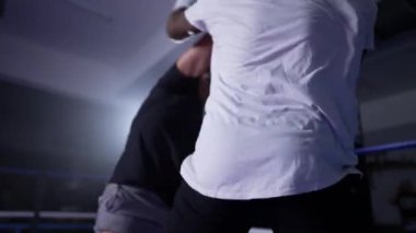 Dövüşçü boks ringinde rakibini yeniyor, Muay Thai dövüşçüleri karşılaşmada, rakibi galibiyet maçında yere seriyor