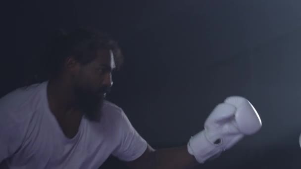 ボクサー交換パンチとキックインテンスマッチ ボクシングリングで手袋を着用 劇的な照明 — ストック動画