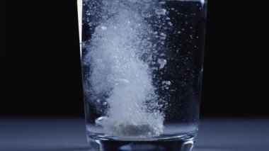 Sağlıklı Yaşam Tarzı veya Spor Ağrısı ve Hastalık Rahatlaması İçin Sıvı Uyuşturucu Çözümü. Temiz Su Kadehinde Ayırıcı Tablet Çok yavaş çekimde Kapatın